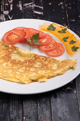 filled omelette with cheese and tomato on white plate