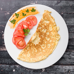 filled omelette with cheese and tomato on white plate