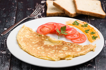 filled omelette with cheese and tomato on white plate