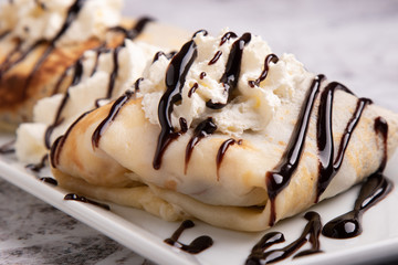 european pancakes, sweet crepe with topping on white long plate