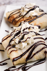 european pancakes, sweet crepe with topping on white long plate