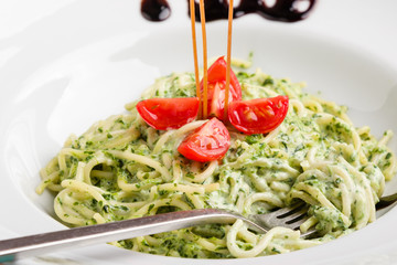tasty spinach with spaghetti pasta on white plate