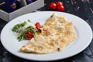 filled omelette with cheese and tomato on white plate