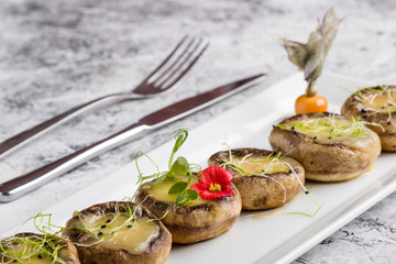 grilled mushroom stuffed with cheese on white plate
