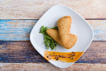 tasty fresh fried breaded cheese on white palte