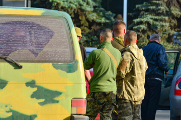 Military soldiers inspect civilian cars to prevent terrorist attacks.