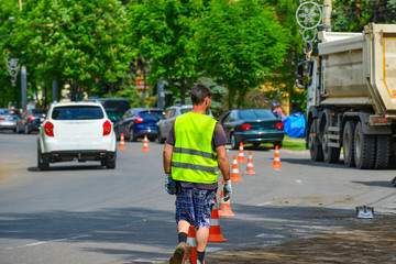 Road worker in protective clothes on the repair of the road.