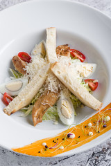 fresh tasty caesar salad appetizer in white plate