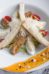 fresh tasty caesar salad appetizer in white plate