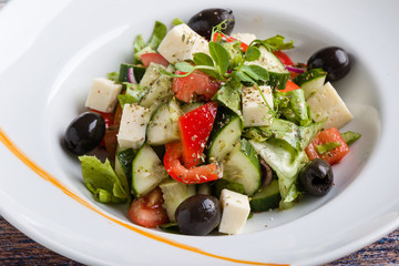 fresh tasty greek salad appetizer on white plate