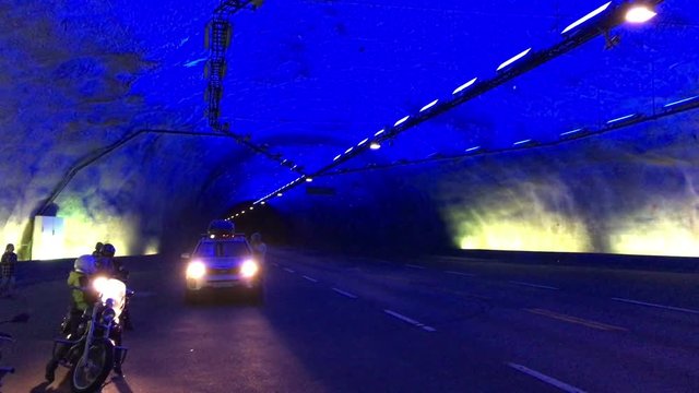 Drivers and motorcyclists stop inside of Laerdal tunnel for watching the interior and color light. Travel by car and motorctycles on Norway, Europa