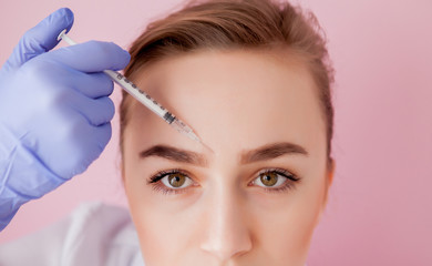 The doctor cosmetologist makes the Rejuvenating facial injections procedure for tightening and smoothing wrinkles on the face skin of a beautiful, young woman in a beauty salon.Cosmetology skin care