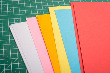 Papers for art of different size on green cutting mat