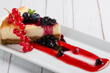 fresh tasty cheese cake with fruits on white plate