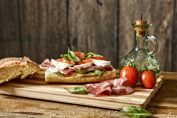 prepare a sandwich with Italian ham, mozzarella and tomato - eat healthy and traditional - desaturated effect - selective focus - closeup