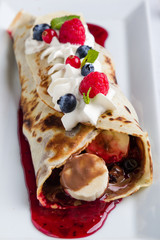 european pancakes, sweet crepe with topping on white long plate