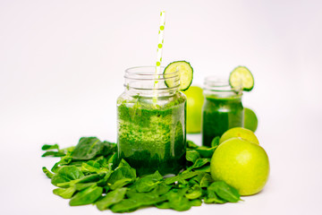 green smoothie in a glass Cup surrounded by green vegetables and fruits for health, diet and weight loss, vegetarianism. close up. blur.