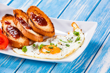 Breakfast - fried egg, toasts and vegetable salad