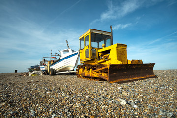 Old yellow bulldozer on a pebble beach