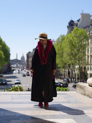 Femme manteau et écharpe rouge devant les colonnes de la madeleine