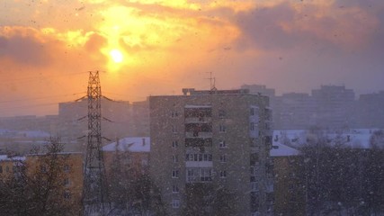 Snowfall snow falling snowstorm in winter city during epic sunset. Slow motion, 4K UHD.