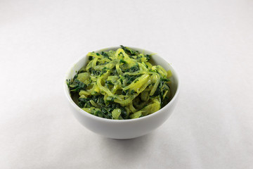 Stir fried spinach and onion. Concept of vegan food or garnish at least. White background.