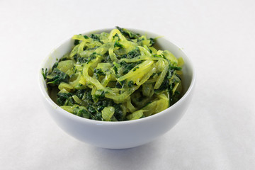Stir fried spinach and onion. Concept of vegan food or garnish at least. White background.