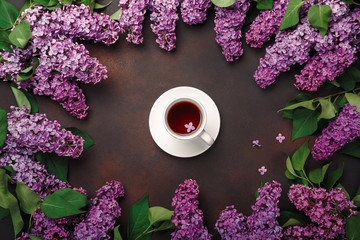 A bouquet of lilacs with cup of tea on rusty background