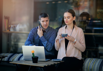 Two businesspeople working together in a local cafe. Businesspeople working together on a cafe terrace. Attractive businesswoman drinking coffee