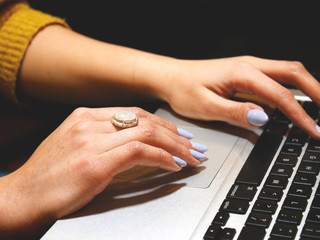 female hands typing on laptop keyboard
