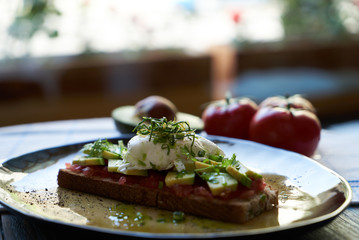 Avocado Toast and Poached Egg with Baked Tomatoes, close-up
