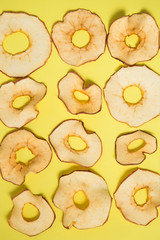 Apple chips on yellow background.Dried apple rings sprinkled with cinnamon on yellow background.healthy vegan snack,copy space