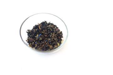 зеленый чай с лепестками василька в стеклянной миске на белом фоне