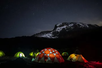 Photo sur Plexiglas Kilimandjaro Tentes éclairées la nuit devant le mont Kilimandjaro