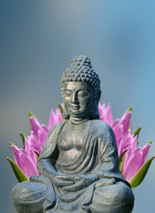 Buddha statue with lily flower behind it. Religious theme template with space for text.