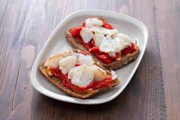 corn bread with cod fish and courgette on white dish