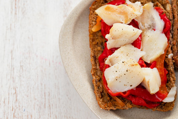 corn bread with cod fish and courgette on white dish