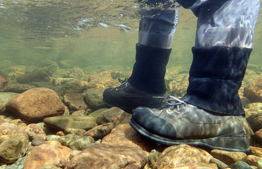 Fisherman's wading boots viewed from under water - obrazy, fototapety, plakaty