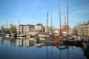 old museum harbor of Gouda with historic ships at mallegatsluis sluice to the Hollandsche IJssel in the Netherlands