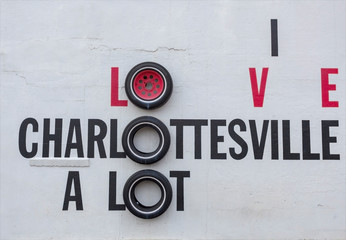 I LOVE CHARLOTTESVILLE roadside attraction sign made with tires mounted on white wall.