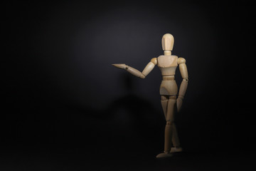 A wooden mannequin shows with his hand. The concept of pointing at someone with your finger. The...