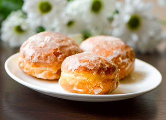 Obraz na płótnie Canvas Homemade donuts on white plate with flowers