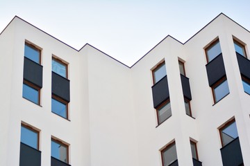 Obraz premium Modern apartment buildings on a sunny day with a blue sky. Facade of a modern apartment building