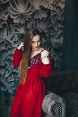 Beautiful woman in red dress in beautiful interior.