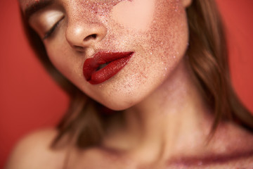 Glamorous woman with glitter make up and empty heart-shaped picture on face