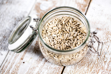 Shelled sunflower seeds in a jar on a wooden background. Healthy vegan food