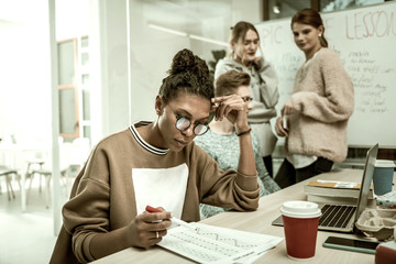 Office trainee wearing glasses feeling busy studying new material