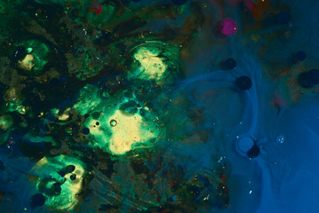 Naklejka na ściany i meble Abstract background of a drop of paint on the water surface. blue green colors