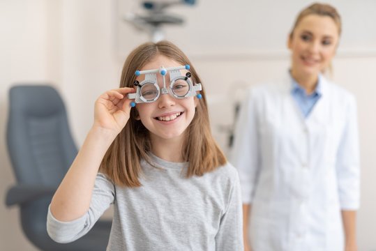 Cute little girl wearing optical trial frame while visiting ophthalmologist