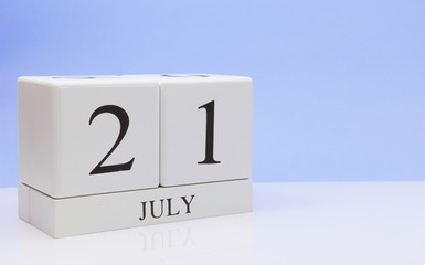 July 21st. Day 21 of month, daily calendar on white table with reflection, with light blue background. Summer time, empty space for text